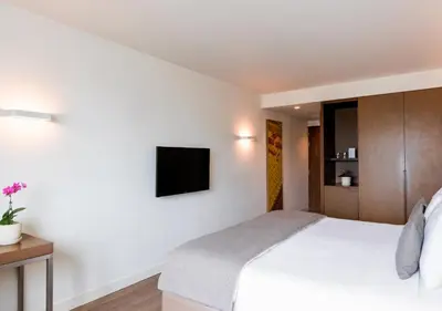 a bedroom with a bed and a tv on the wall at Dazzler by Wyndham Lima San Isidro in Lima