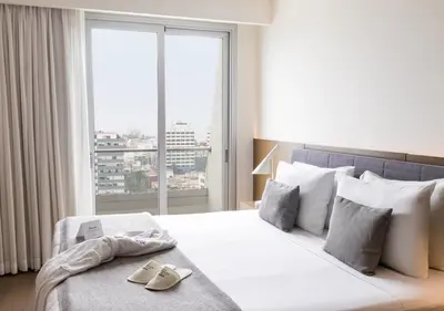a bedroom with a white bed with a large window at Dazzler by Wyndham Lima San Isidro in Lima