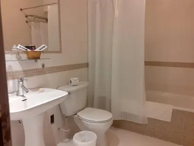 a bathroom with a toilet and a sink and a shower at Hotel Melodia in Lima
