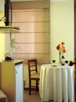a white table with a vase of flowers on it at Hotel Melodia in Lima