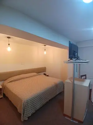 a bedroom with a bed and a television on a table at Hotel Melodia in Lima