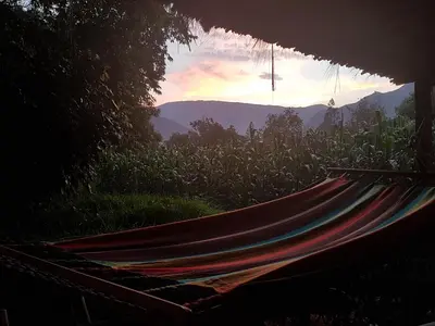 a hammock in a field with the sunset in the background at Mágico lugar en el Valle Sagrado in Cusco