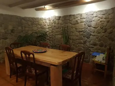 a wooden table in a room with a stone wall at Mágico lugar en el Valle Sagrado in Cusco
