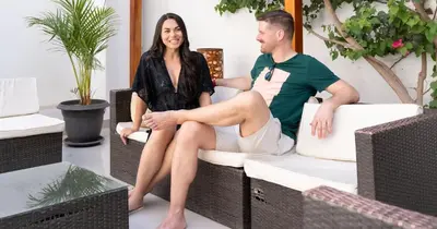 a man and woman sitting on chairs in a living room at Hotel Residencial Los Frayles in Paracas