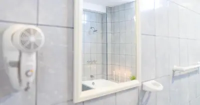 a bathroom with a shower with a mirror and a sink at Hotel Residencial Los Frayles in Paracas