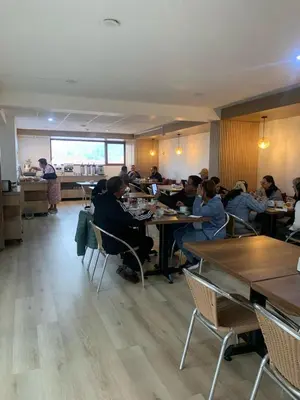 a group of people sitting at tables in a restaurant at Hotel San Pedro Plaza in Cusco