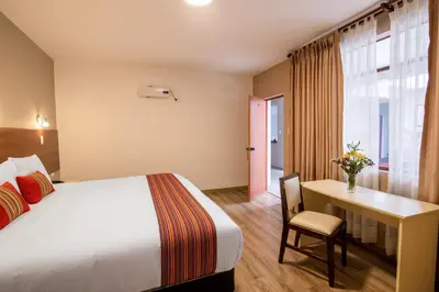 a hotel room with a bed and a desk at Hotel San Pedro Plaza in Cusco