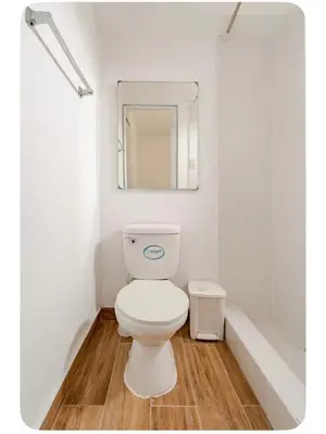 a white bathroom with a toilet and a mirror at Maywa at Central Miraflores in Lima