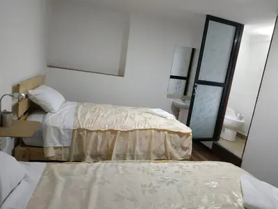 a bedroom with two beds and a mirror and a sink at Casa Anais y Nicolas económico in Cusco