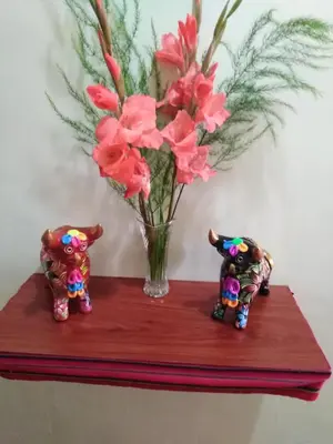 two figurines on a table with a vase of flowers at Secret Garden in Cusco