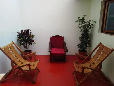 a room with two chairs and a red chair at Secret Garden in Cusco