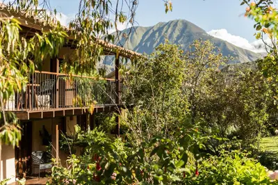 a building with a balcony with mountains in the background at Andenia Boutique Hotel, Sacred Valley in Urubamba