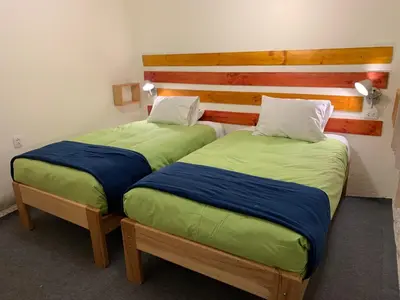 two beds sitting next to each other in a room at Gaia House Hostel in Cusco