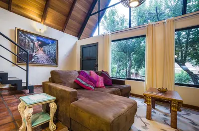 a living room with a couch and large windows at VILLA APU CHICON (Apu Wasi & Inti Wasi) in Urubamba