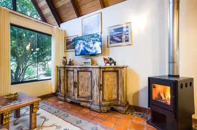 a living room with a wood stove in the corner at VILLA APU CHICON (Apu Wasi & Inti Wasi) in Urubamba