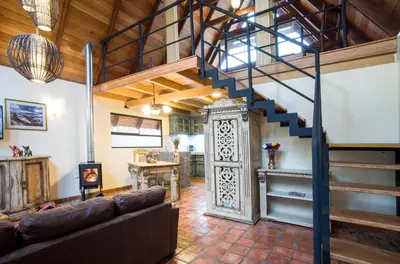 a living room with a spiral staircase in a house at VILLA APU CHICON (Apu Wasi & Inti Wasi) in Urubamba