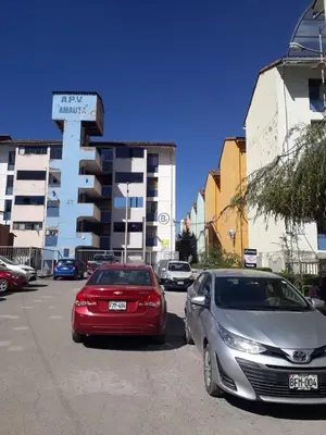 two cars parked in a parking lot in front of a building at Piso de Kireyna in Cusco