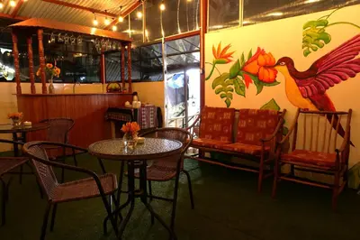 a dining room with tables and chairs and a mural at Welcome Cusco Hostel in Cusco