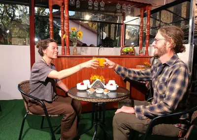 a man and a woman sitting at a table drinking at Welcome Cusco Hostel in Cusco