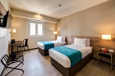 a hotel room with two beds and a television at Arawi Miraflores Express in Lima