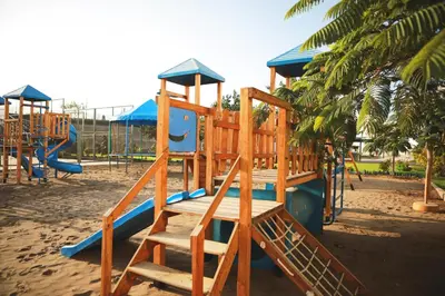 a wooden playground with a slide in the sand at San Agustin Paracas in Paracas