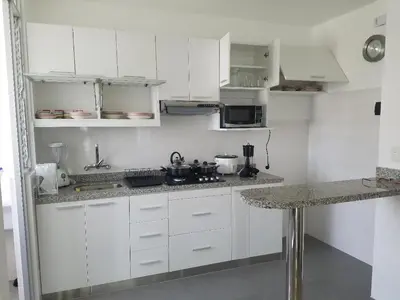 a white kitchen with white cabinets and a counter at Jirón Tarapacá 398, La Punta - Callao in Lima