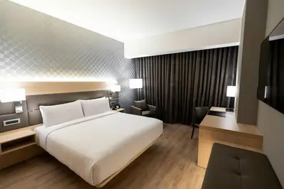 a bedroom with a large white bed and a television at AC Hotel by Marriott Lima Miraflores in Lima