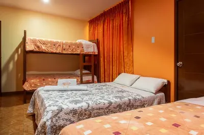two beds in a room with two bunk beds at Refugio Hotel in San Ramón