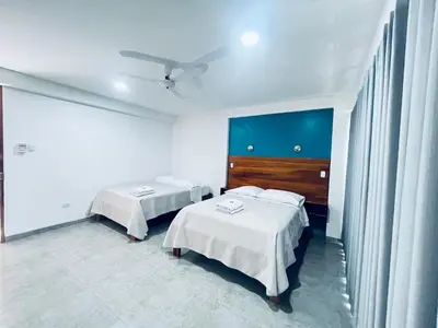 a hotel room with two beds and a window at Hotel Villa Santa Ana in Quillabamba