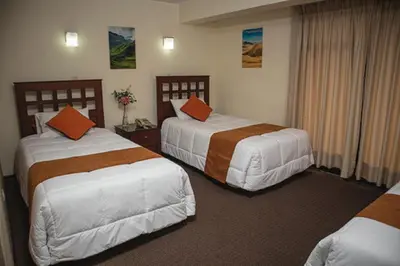 a hotel room with two beds with orange pillows at Hotel Ferrua in Lima
