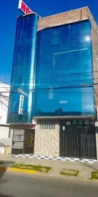 a building with blue glass windows on a street at Hospedaje Manchego's in Huancayo