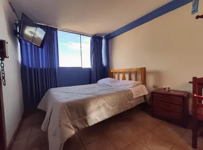 a bedroom with a bed and a large window at Hospedaje Manchego's in Huancayo