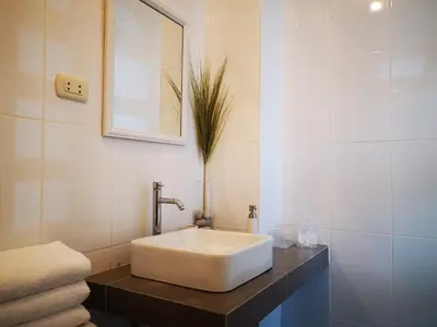a bathroom with a white sink and a mirror at Coco Lodge Paracas in Paracas