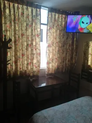 a bedroom with a table and a tv in a room at Mini Departamento Tambo Huascar 2 in Lima