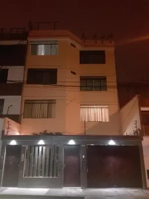 a building with a garage in front of it at night at Mini Departamento Tambo Huascar 2 in Lima