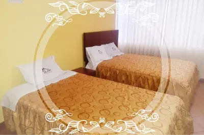 a hotel room with two beds and a window at Hospedaje Las Lilas in Huancayo