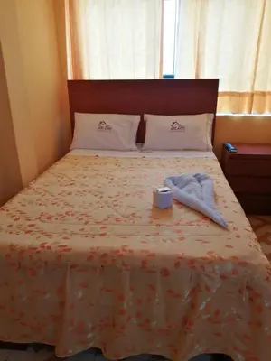 a bed with a towel and a box on it at Hospedaje Las Lilas in Huancayo