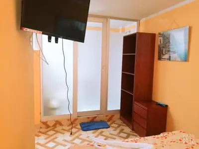 a bedroom with a large window and a tv at Hospedaje Las Lilas in Huancayo
