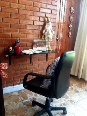 a black office chair sitting next to a brick wall at Casa Montemira in Ica