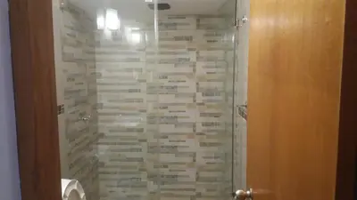 a bathroom with a shower with a stone wall at Departamento en el centro de San Borja (Rubens) in Lima