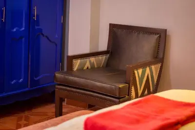 a chair in a room next to a bed at Bull House in Urubamba