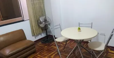 a room with a table and a chair and a fan at Peruvian Family Hostal Miraflores in Lima