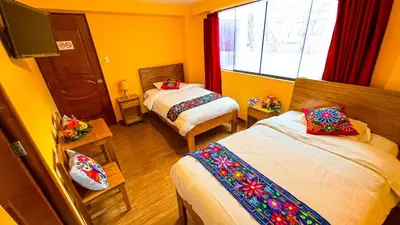 a hotel room with two beds and a window at Andean Atoq Hostel in Cusco