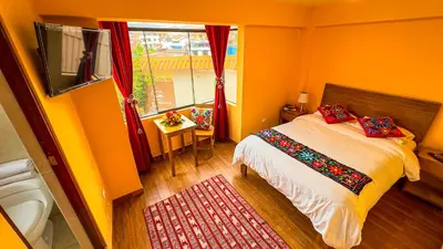 a bedroom with a bed and a window at Andean Atoq Hostel in Cusco