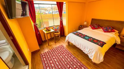 a small bedroom with a bed and a window at Andean Atoq Hostel in Cusco