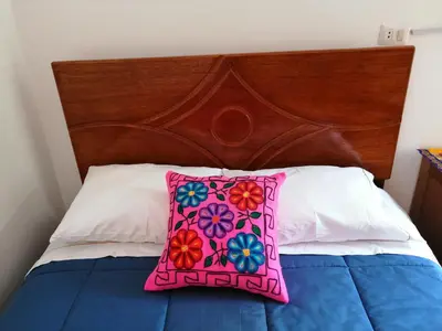 a pink pillow sitting on top of a bed at Kenti's Home Ollantaytambo in Ollantaytambo