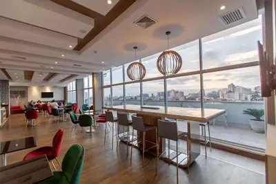 a dining room with large windows and a view of the city at Hampton By Hilton Lima San Isidro in Lima