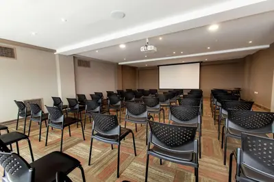 a conference room with chairs and a screen at Hampton By Hilton Lima San Isidro in Lima