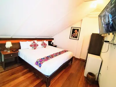 a bedroom with a white bed and a television at Posada San Blas in Cusco
