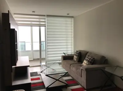 a living room with a couch and a glass table at Moderno departamento Miraflorino con aire acondicionado in Lima